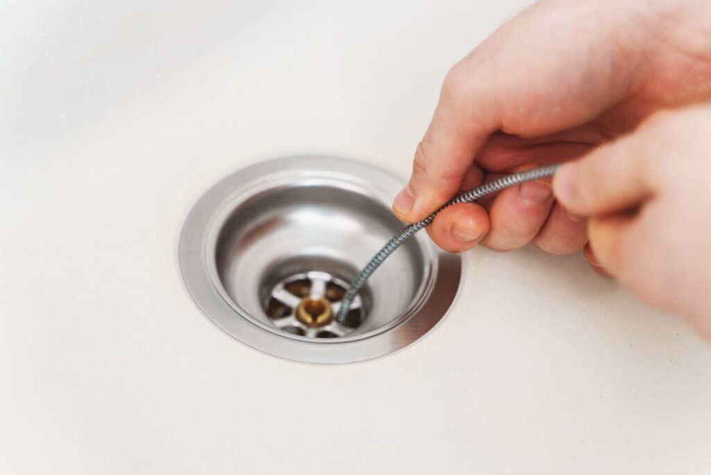 drain snake unclogging a sink